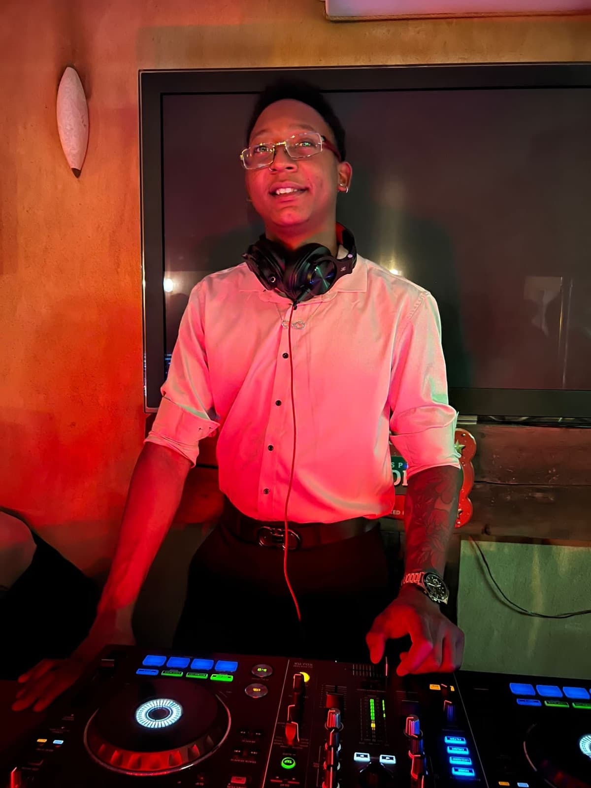 DJ Kenny en cabina con luz cálida